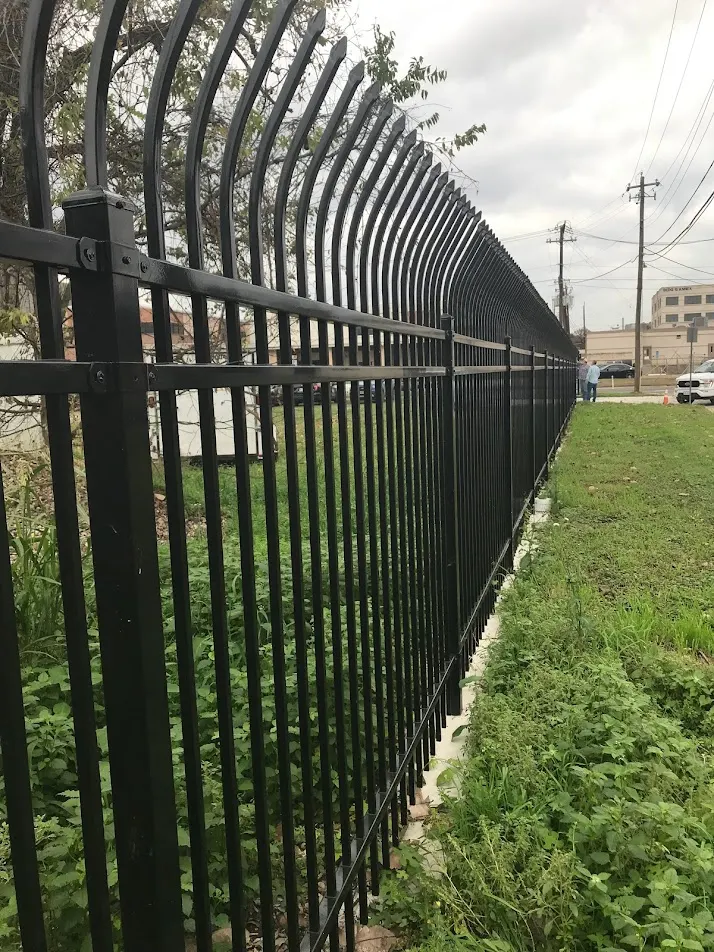 Tall black aluminum security fence with curved spear tops