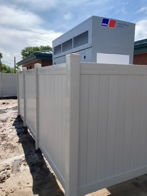 White vinyl privacy fence around an HVAC enclosure